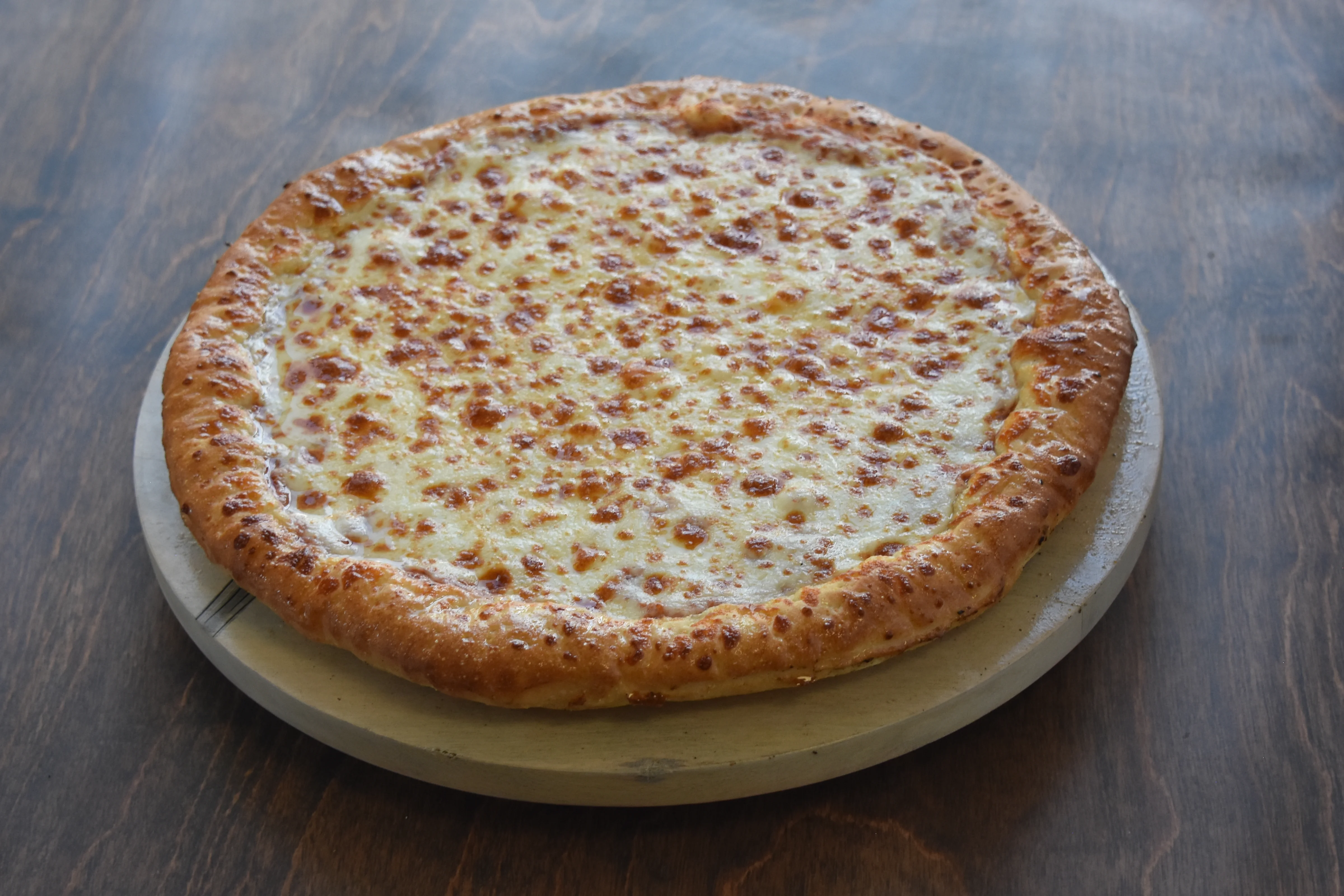 Cheesy pizza on a wooden serving board.