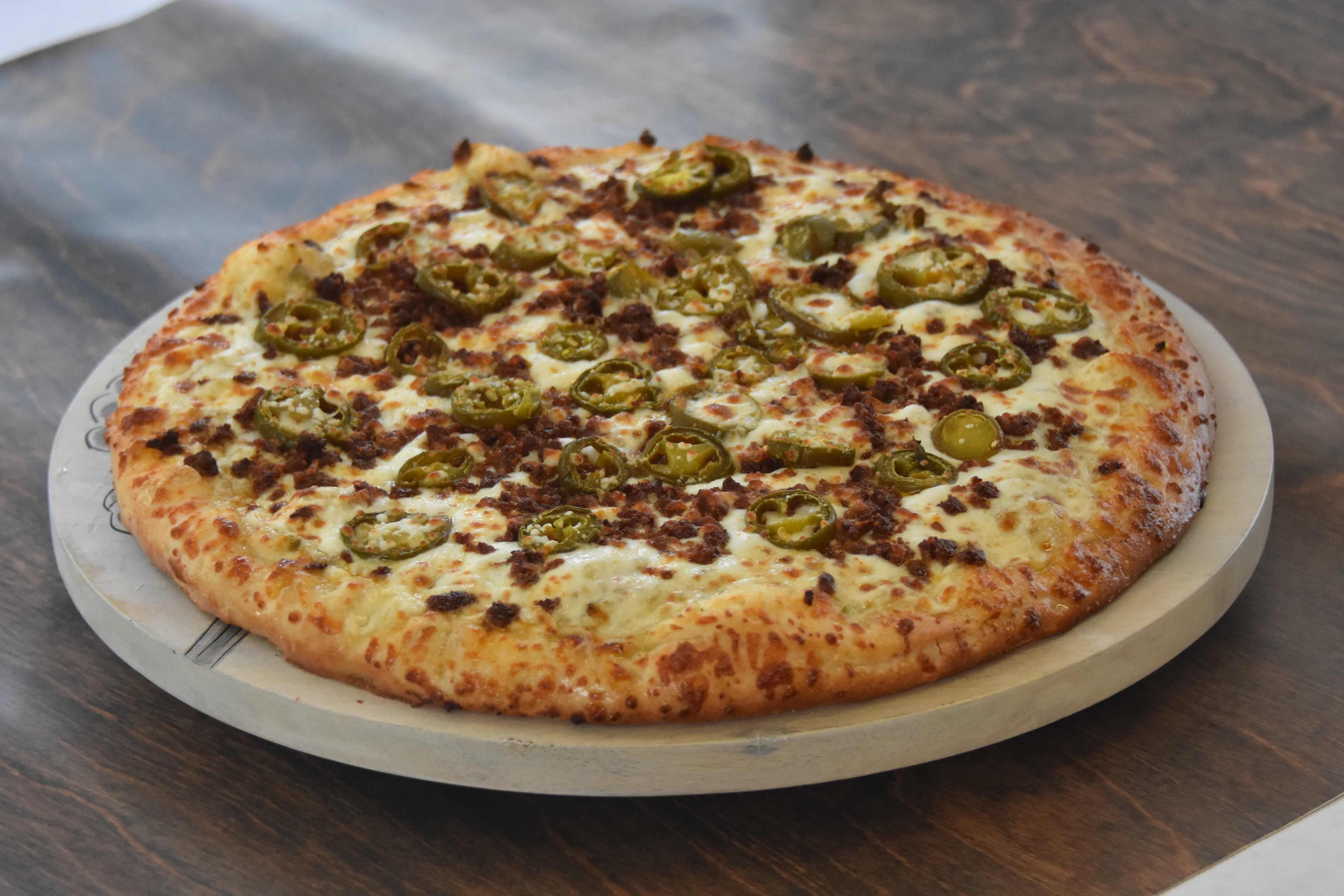 Delicious pizza topped with jalapeños and ground meat