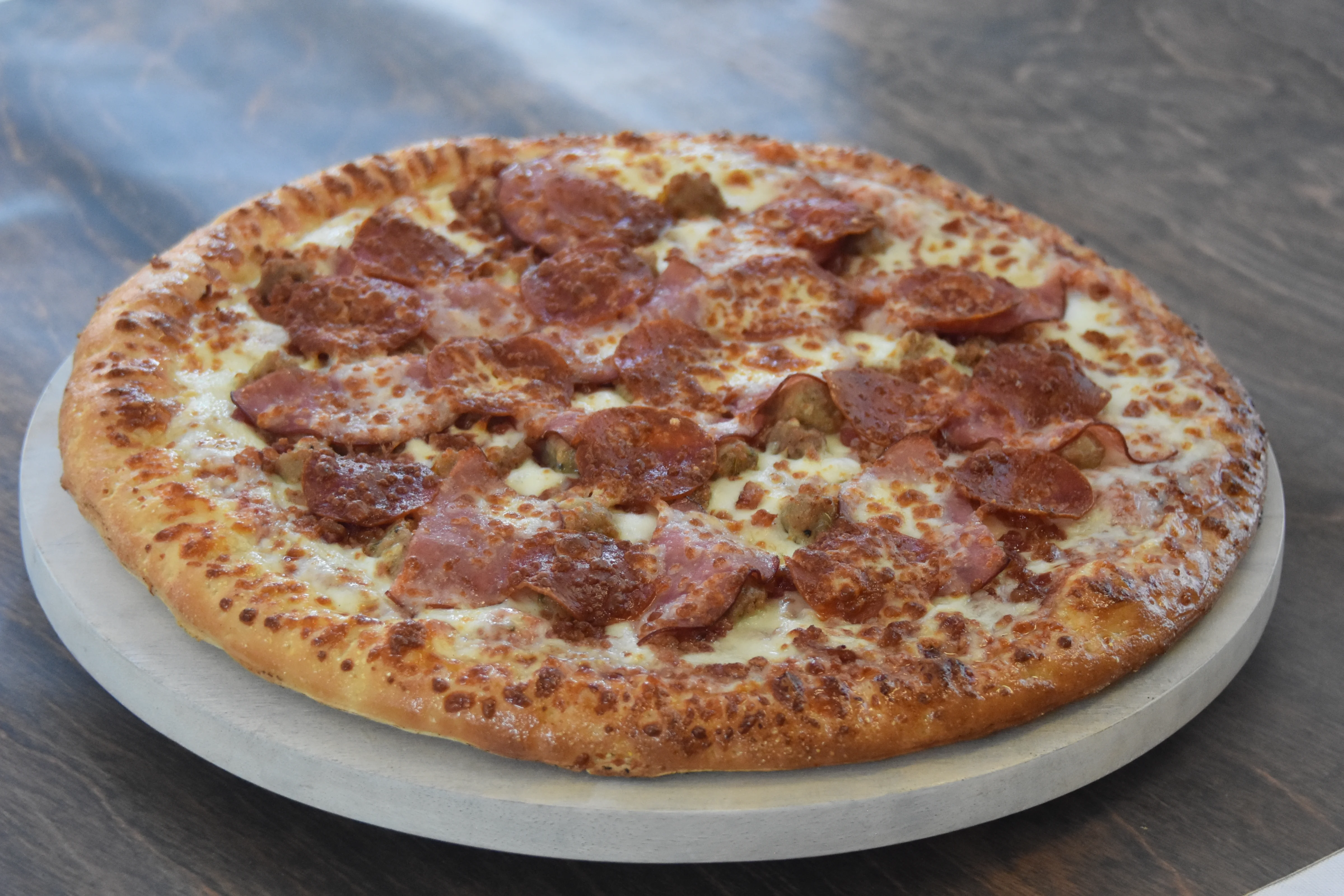 Delicious pepperoni and sausage pizza on wood table