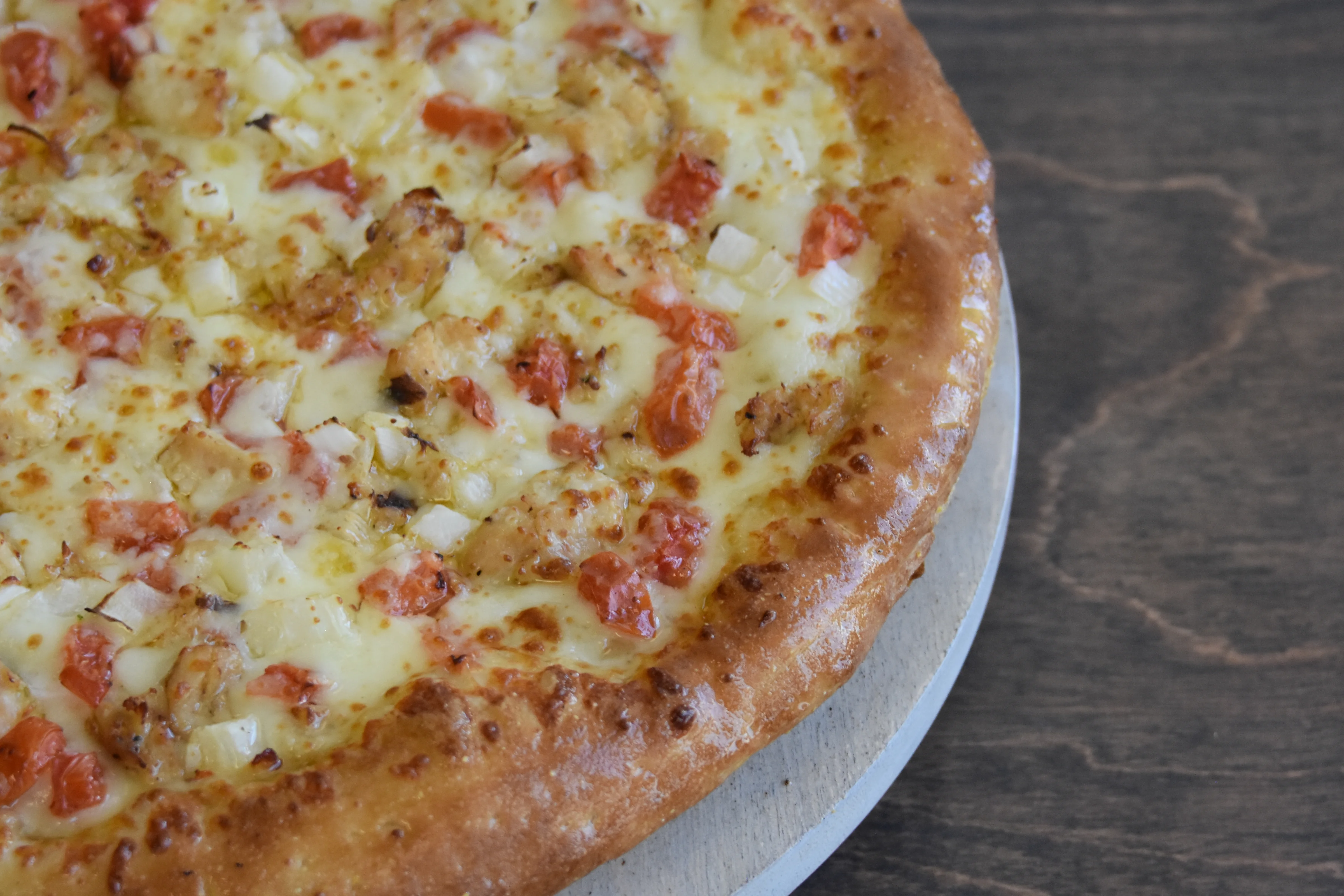 Delicious pizza with cheese, chicken, and diced tomatoes